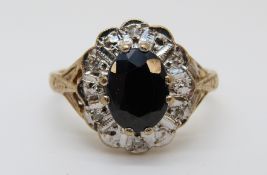 A 9ct gold ring set with a sapphire surrounded by diamonds (size L)