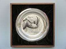 A white metal shallow plate decorated with a rhinoceros by Bernard Buffet,