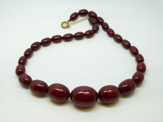 A cherry amber necklace of 29 graduated ovoid beads, the largest approximately 16x22mm, 26g,