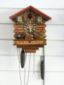 A c1950s Black Forest cuckoo clock by Kianec with Alpine lodge decoration to case,