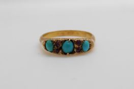 A hallmarked 9ct gold ring set with three turquoise cabochon and four rubies Birmingham 1910 (size