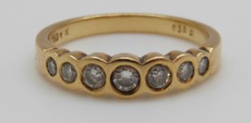 An 18ct gold ring set with seven round brilliant cut diamonds totalling approximately 0.