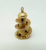 A 9ct gold charm/ pendant in the form of a helter skelter opening to reveal a girl with a mat, 4.