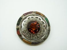 A Victorian silver Scottish brooch set with a large citrine within a pierced border surrounded by