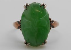 A 9ct gold ring set with a carved jadeite cabochon, 3.