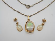 A silver pendant set with an oval opal and a pair of matching earrings