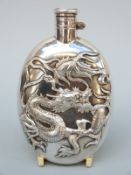 A Chinese white metal hip flask decorated with a dragon and having a bayonet cap,