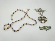 A silver necklace set with moonstones and a beaded necklace