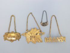 Three gilt bottle tickets comprising leaf shaped Gin example, Rum and Brandy,
