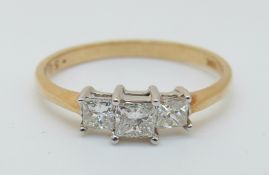 An 18ct gold ring set with three princess cut diamonds, total 0.