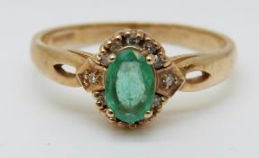 A 9ct gold ring set with an oval emerald surrounded by diamonds (size O)