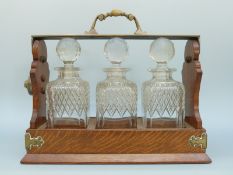 A Betjemann's patent oak three bottle tantalus, height 29cm,