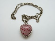 A silver necklace set with a millefiori heart pendant