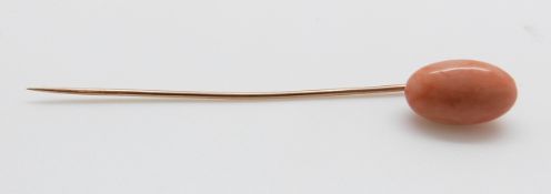 A stick pin set with a large coral cabochon, 6.5cm (cabochon 1.