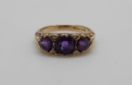 A 9ct gold ring set with three amethysts and four diamonds, 3.