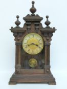 A late 19thC / early 20thC oak cased mantel clock with reeded and finial decoration the brass dial