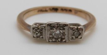 A 9ct gold ring set with three diamonds in a palladium setting, 1.