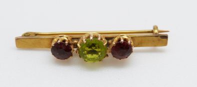 A 15ct gold brooch set with a peridot and two garnets, 3.