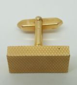 A gold cufflink with engine turned design (9.