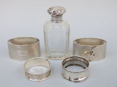 A pair of oval hallmarked silver engine turned napkin rings and two further napkin rings,