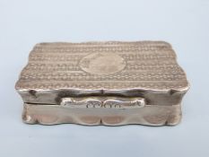 A George V hallmarked silver snuff box with shaped edge and engine turned decoration,