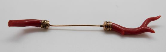 A gold jabot pin with a piece of branch coral to each end, 11.