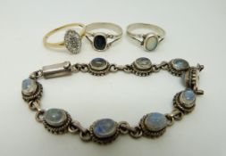 Three silver rings, one set with an opal,