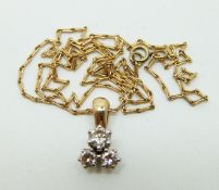 An 18ct gold pendant set with three diamonds, the largest measuring approximately 0.