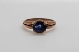 A yellow metal ring set with a sapphire (size L/M)