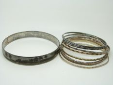 Nine silver bangles and a large silver niello flapper bangle