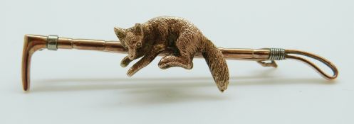 A 9ct gold brooch in the form of a fox and whip with textured detail, in Hong Kong box, 51cm, 4.