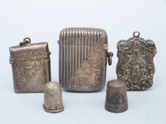 Two hallmarked silver vesta cases, a white metal vesta and two thimbles, one hallmarked silver,