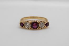 An 18ct gold ring set with three rubies the largest approximately 0.