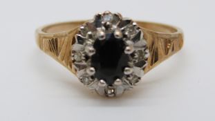 A 9ct gold ring set with a sapphire surrounded by diamonds