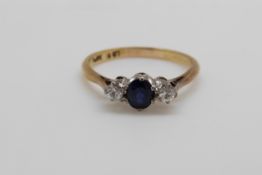 An 18ct gold ring set with a sapphire and two diamonds in a platinum setting (size O)