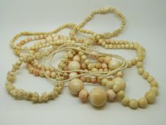 Two ivory necklaces and a carved bone example