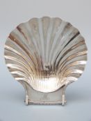 A Victorian hallmarked silver shell shaped dish raised on three feet shaped as molluscs,
