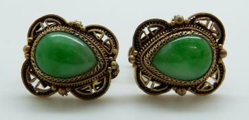 A pair of earrings set with a pear cut jade cabochons