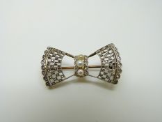 An 18ct gold brooch in the form of a bow set with rose cut diamonds and three pearls to the centre,