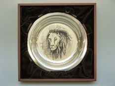 A white metal shallow plate decorated with a lion by Bernard Buffet,