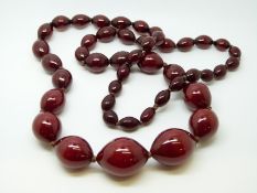 A cherry amber necklace of 46 graduated ovoid beads, the largest approximately 22x20mm, 80g,
