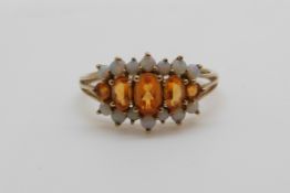 A 9ct gold ring set with citrines and opals (size T)
