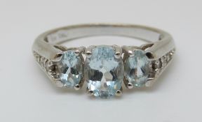 A 10K white gold ring set with blue topaz and diamonds to the shoulders (size N)