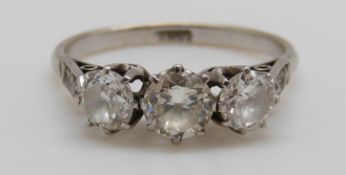 A platinum ring set with three round brilliant cut diamonds with further diamonds to the shoulders,