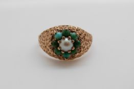 A 9ct gold ring set with a seed pearl surrounded by turquoise cabochons (size M)