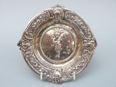 A Victorian hallmarked silver embossed dish depicting a cherub playing a violin,