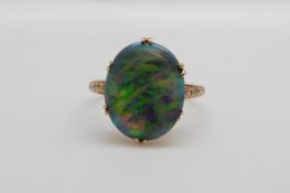 A Victorian 15ct gold ring set with a black opal cabochon, 1.5cm x 1.