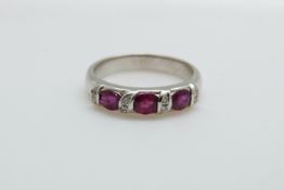 An 18ct white gold ring set with three rubies and diamonds, 4.