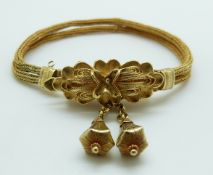 A two strand woven yellow metal Victorian rope bracelet with drop sections and a stylized floral