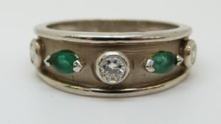 A 9ct white gold ring set with diamonds and emeralds (size O)